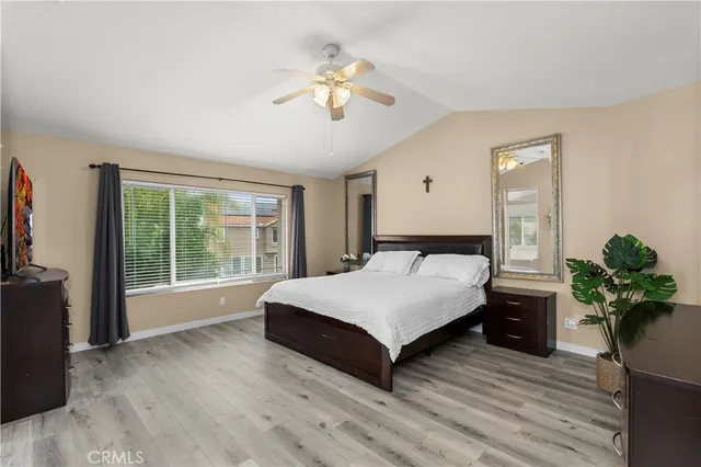 a spacious bedroom with a large bed and a chandelier
