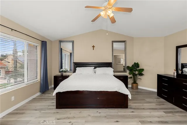 a spacious bedroom with a bed and wooden floor