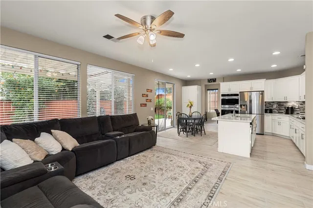 a living room with furniture kitchen view and a large window