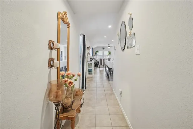 a hallway with a view of living room with wooden floor
