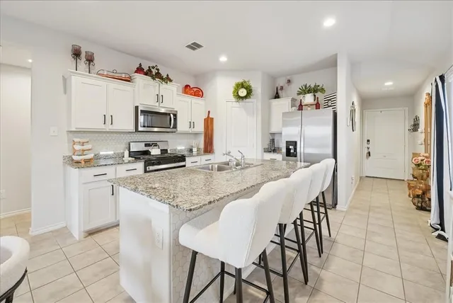 a kitchen with stainless steel appliances kitchen island granite countertop a sink and cabinets