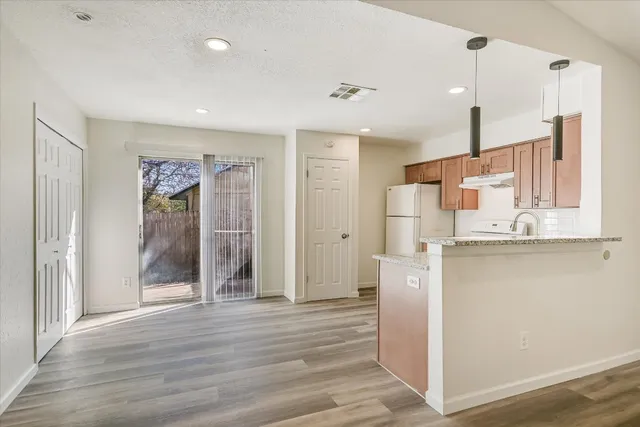 a kitchen with stainless steel appliances granite countertop a refrigerator and a sink