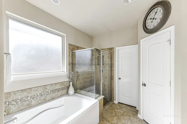a bathroom with a granite countertop bathtub and a shower