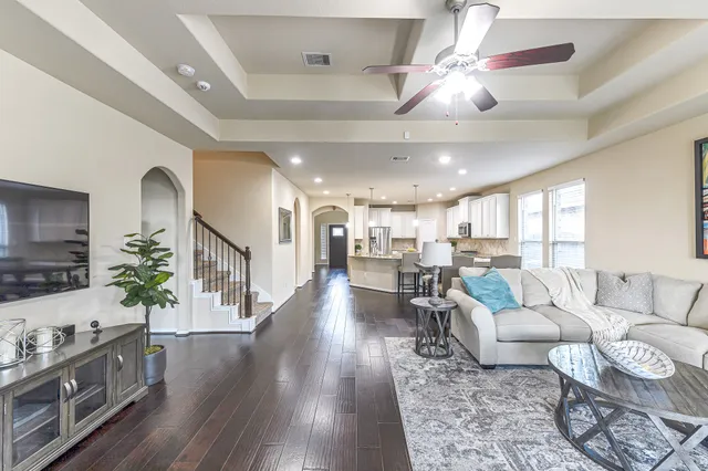 a living room with furniture and a wooden floor