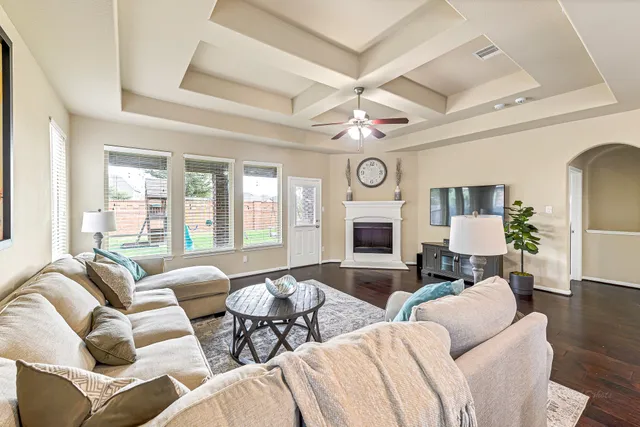 a living room with furniture a fireplace and a large window