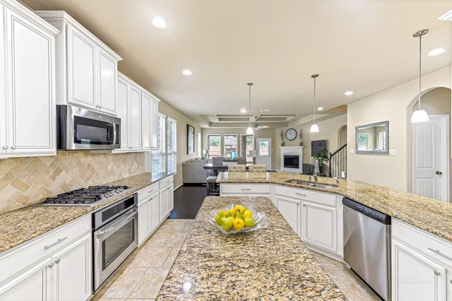 a large kitchen with kitchen island granite countertop a stove and a sink