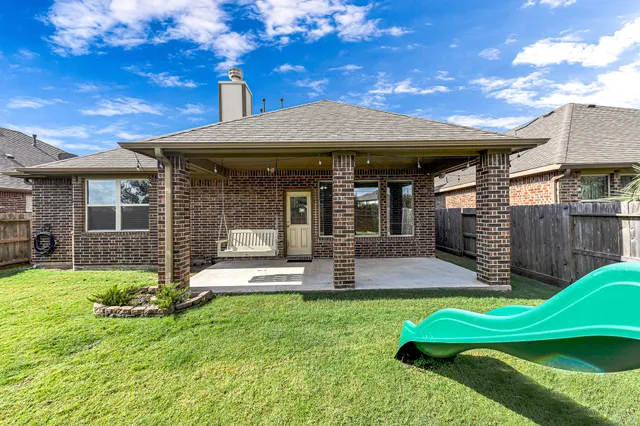 a view of a house with a yard patio and a garden