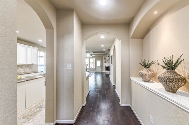 a hallway with stainless steel appliances kitchen island granite countertop furniture and wooden floor