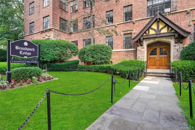 a front view of a house with a yard and potted plants