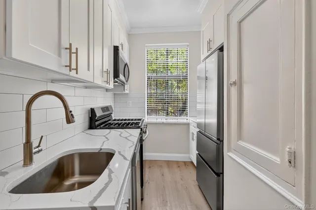 a kitchen with a sink cabinets a stove and a refrigerator