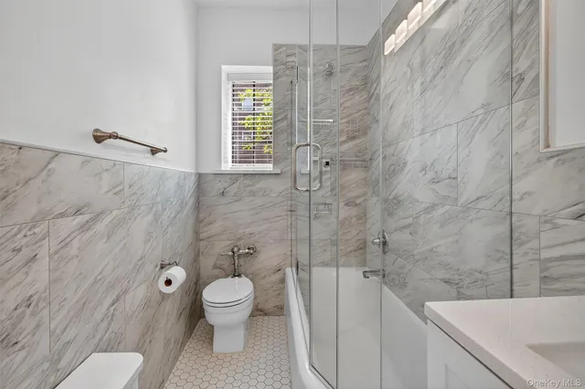 a bathroom with a granite countertop toilet a sink and a shower
