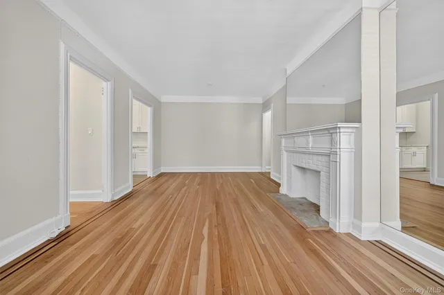 a view of empty room with wooden floor and fireplace