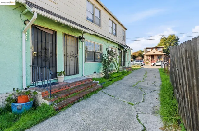 a backyard of a house with barbeque oven table and chairs