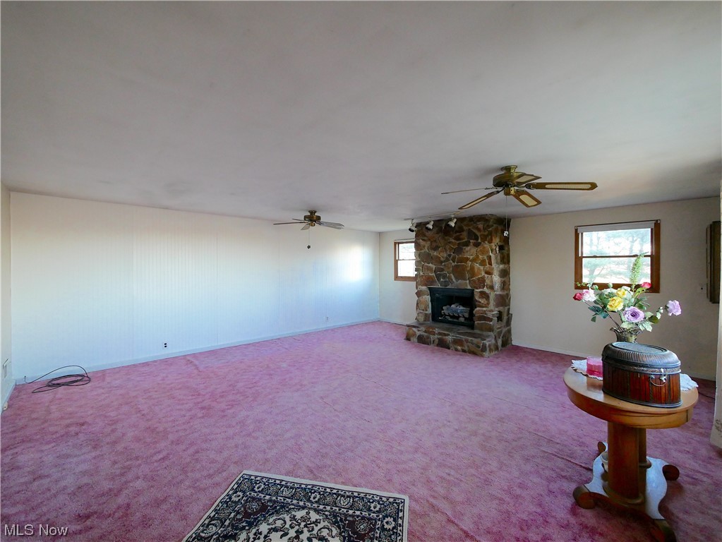 61784 Ray Ramsey Road Shadyside, OH 43947 - Photo 11 of 29 Living room with a stone fireplace, ceiling fan, and carpet flooring