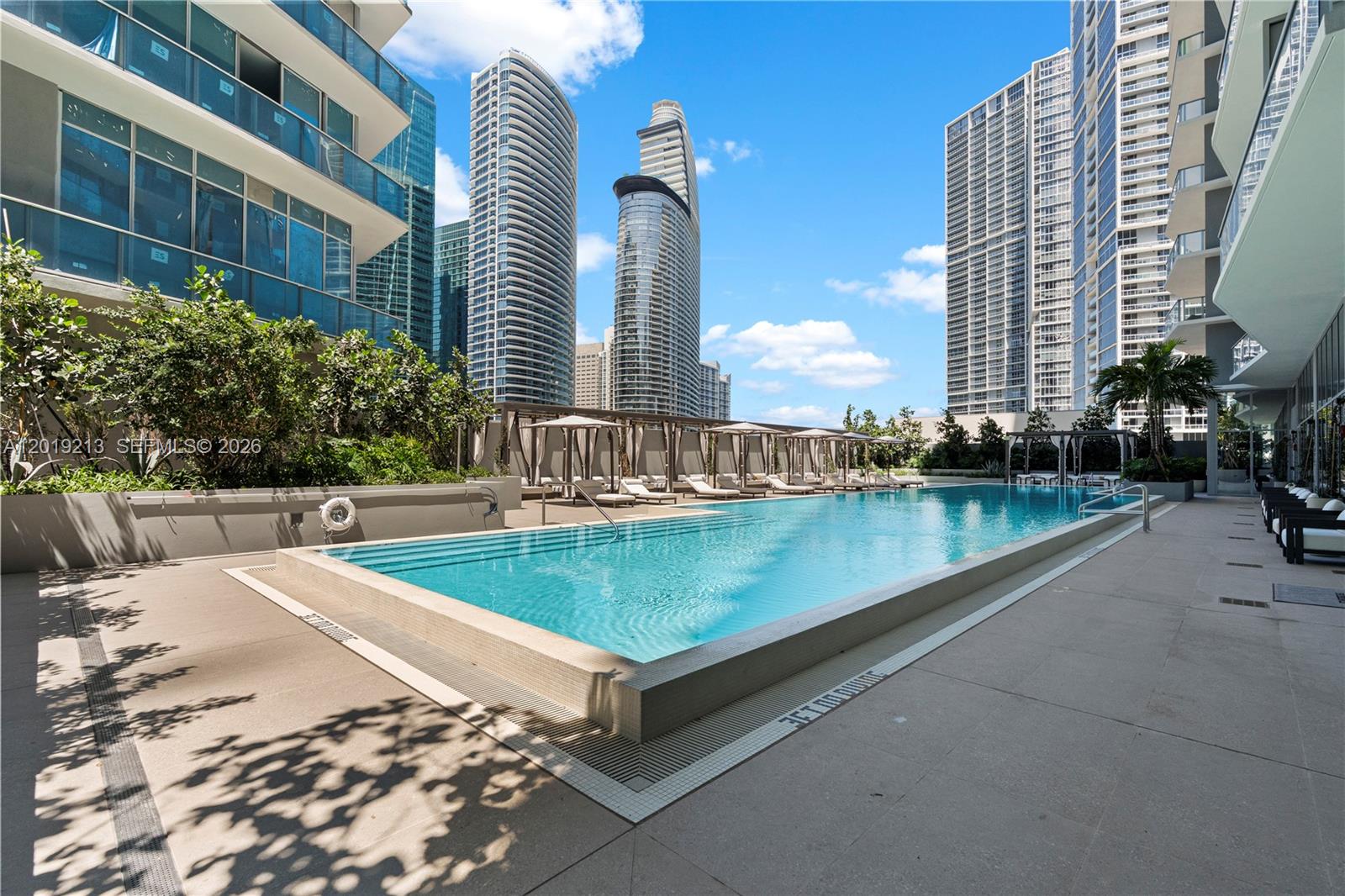 77 Southeast 5th, Unit 3702 Miami, FL 33131 - Photo 41 of 63 a view of a swimming pool with a lounge chairs