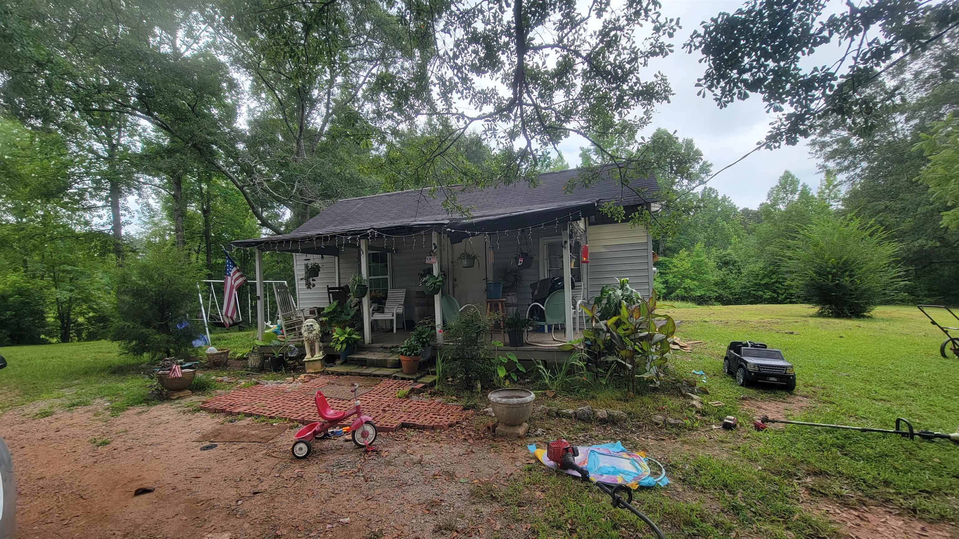 63 Allen Spur Road Grantville, GA 30220 - Photo 1 of 1 a backyard of a house with barbeque oven table and chairs