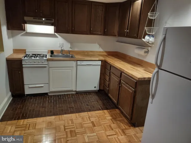 a kitchen with a sink a stove and cabinets