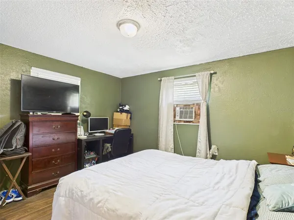 a bedroom with a bed and wooden floor