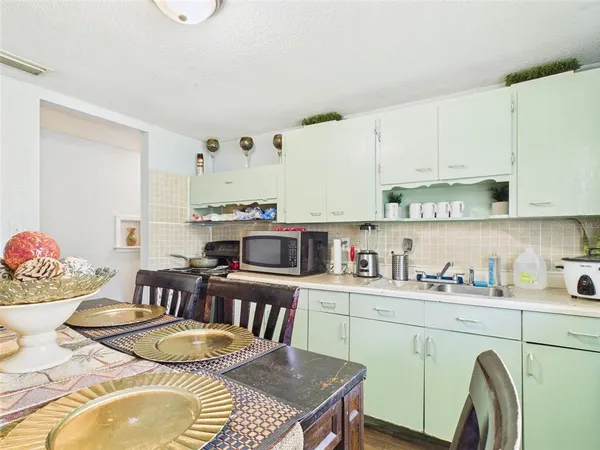 a kitchen with a table chairs stove and cabinets
