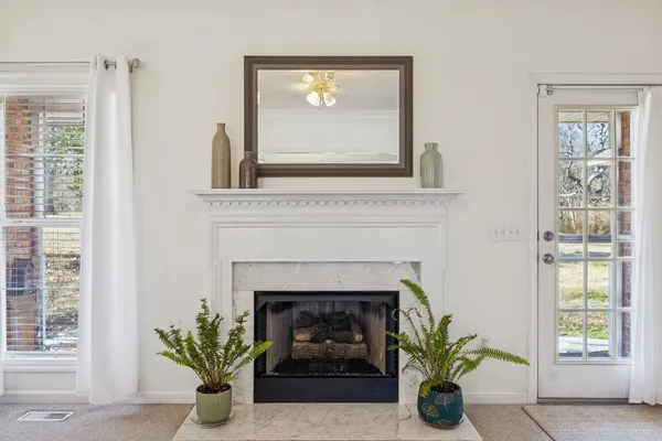 a living room with a fireplace and windows