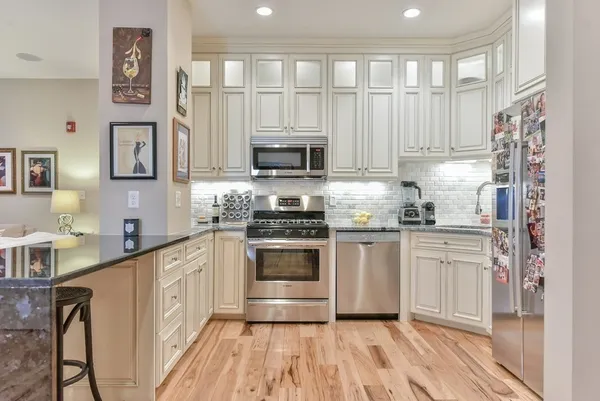 a kitchen with stainless steel appliances granite countertop a stove a sink and a refrigerator