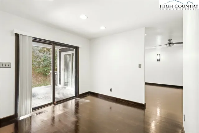 a view of a hallway with wooden floor and a living room