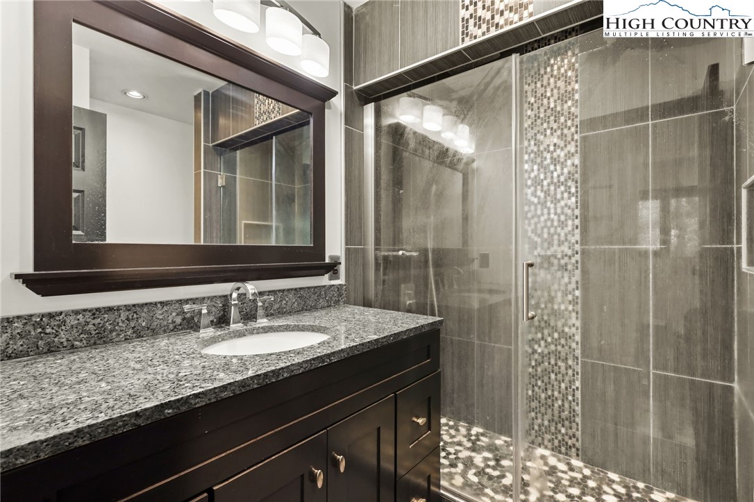 178 Brook Lane Boone, NC 28607 - Photo 26 of 48 a bathroom with a granite countertop sink a mirror and shower