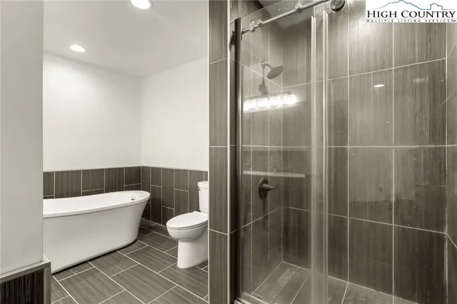 a bathroom with a granite countertop bathtub a sink a toilet and a mirror