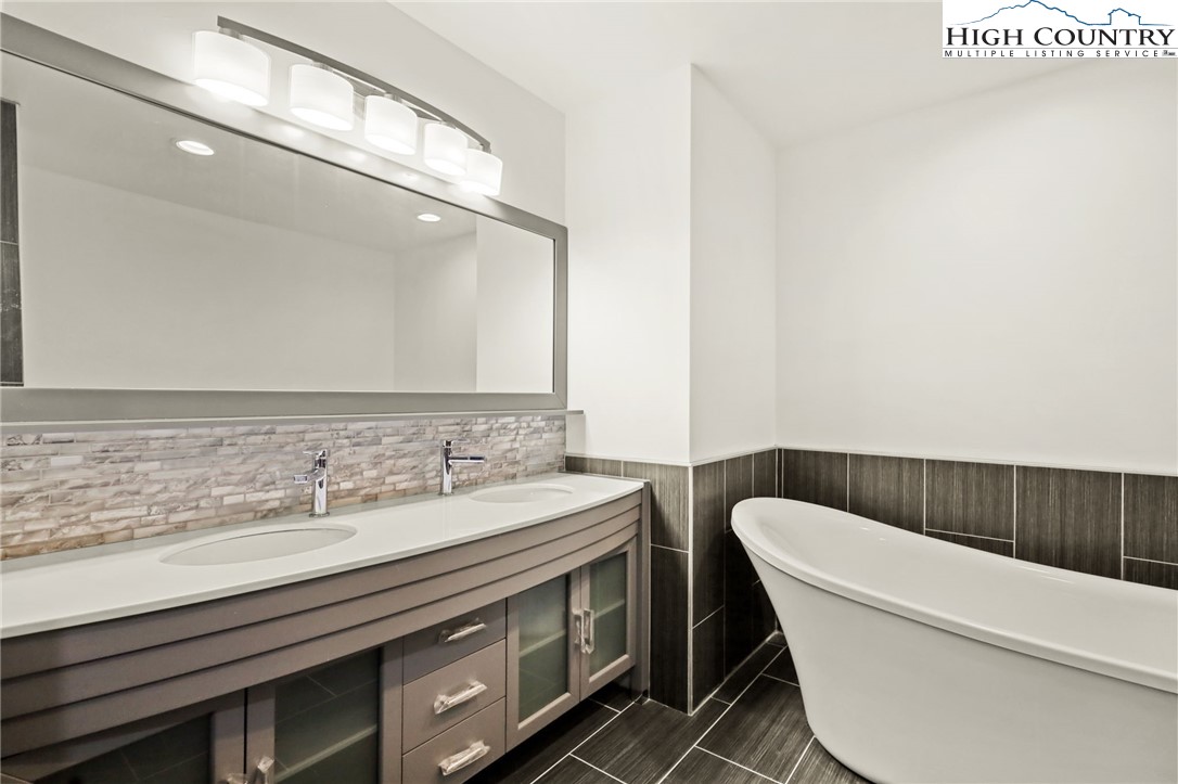 178 Brook Lane Boone, NC 28607 - Photo 33 of 48 a bathroom with a granite countertop bathtub a sink a toilet and a mirror