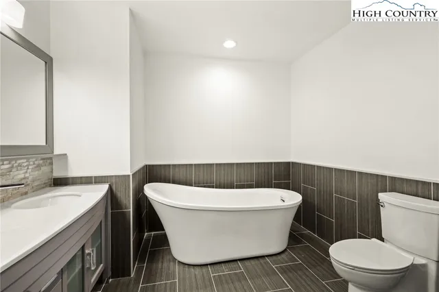 an empty room with wooden floor closet and windows