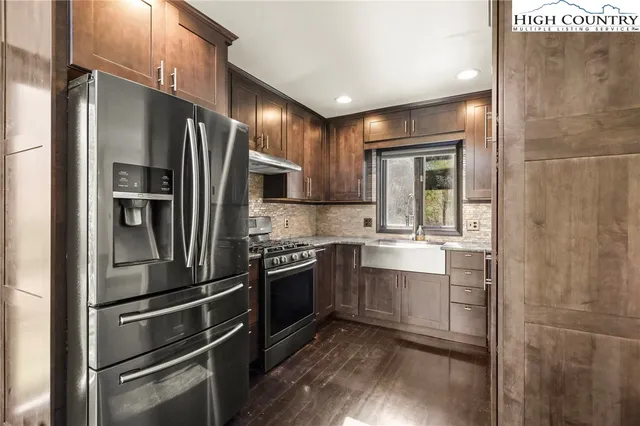 a kitchen with granite countertop wooden cabinets and stainless steel appliances