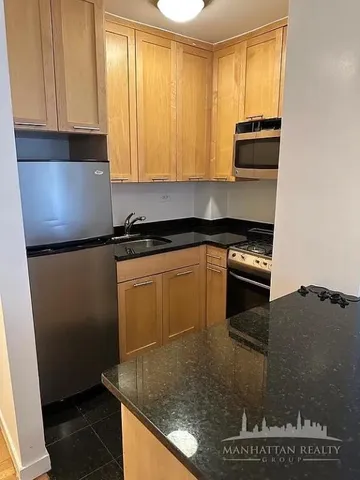 a kitchen with stainless steel appliances granite countertop a sink stove and microwave