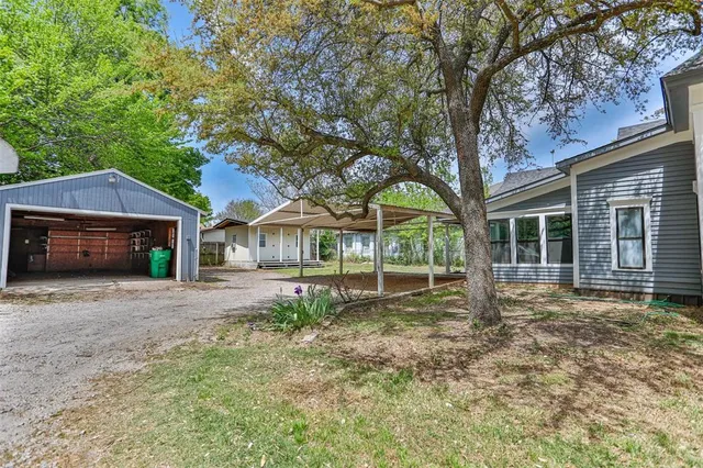 a front view of a house with a garden and trees