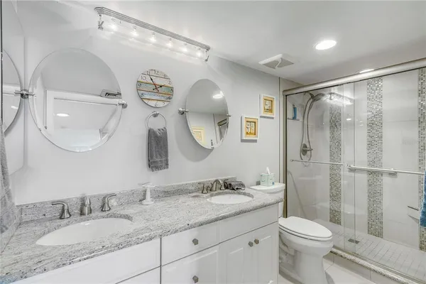a spacious bathroom with a granite countertop double vanity sink and a mirror