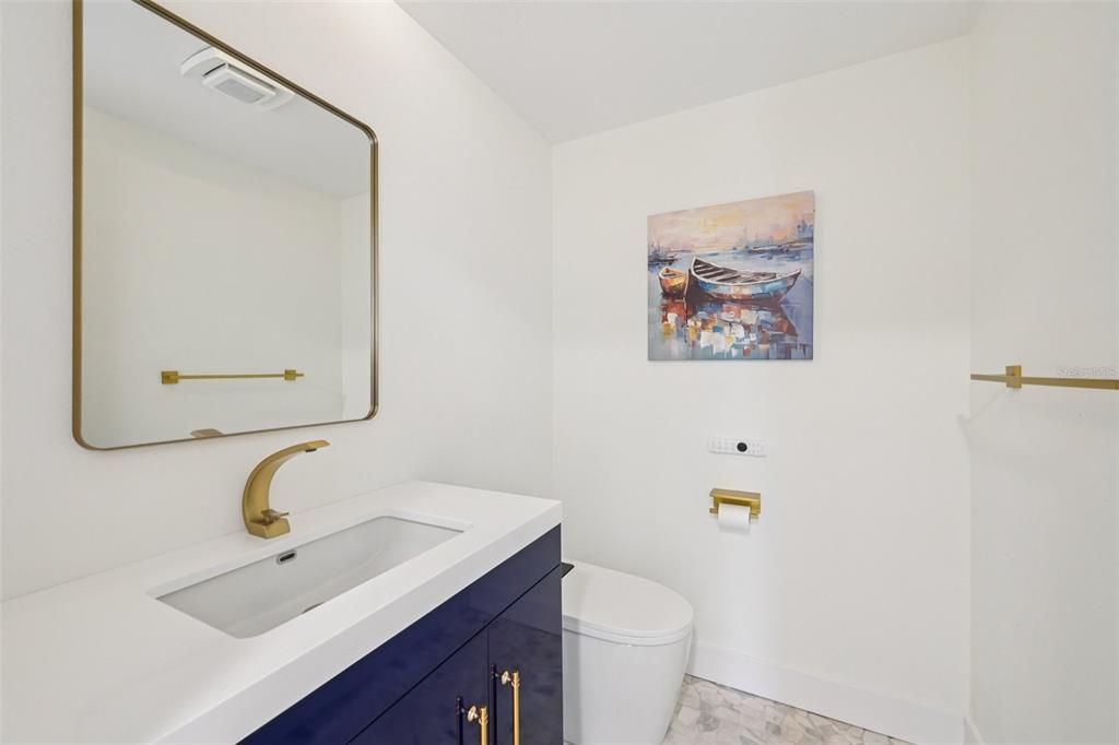 2450 Harbourside Drive, Unit 244 Longboat Key, FL 34228 - Photo 21 of 46 a bathroom with a toilet a sink and mirror