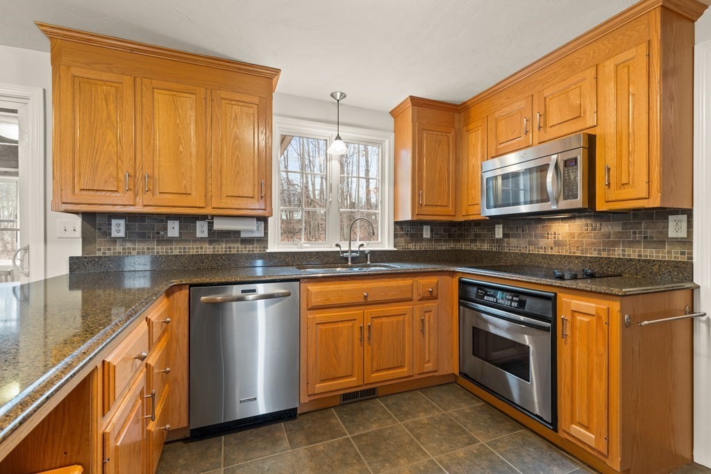 246 Morgan Road Whitinsville, MA 01588 - Photo 8 of 28 a kitchen with stainless steel appliances granite countertop wooden cabinets a stove a sink and dishwasher