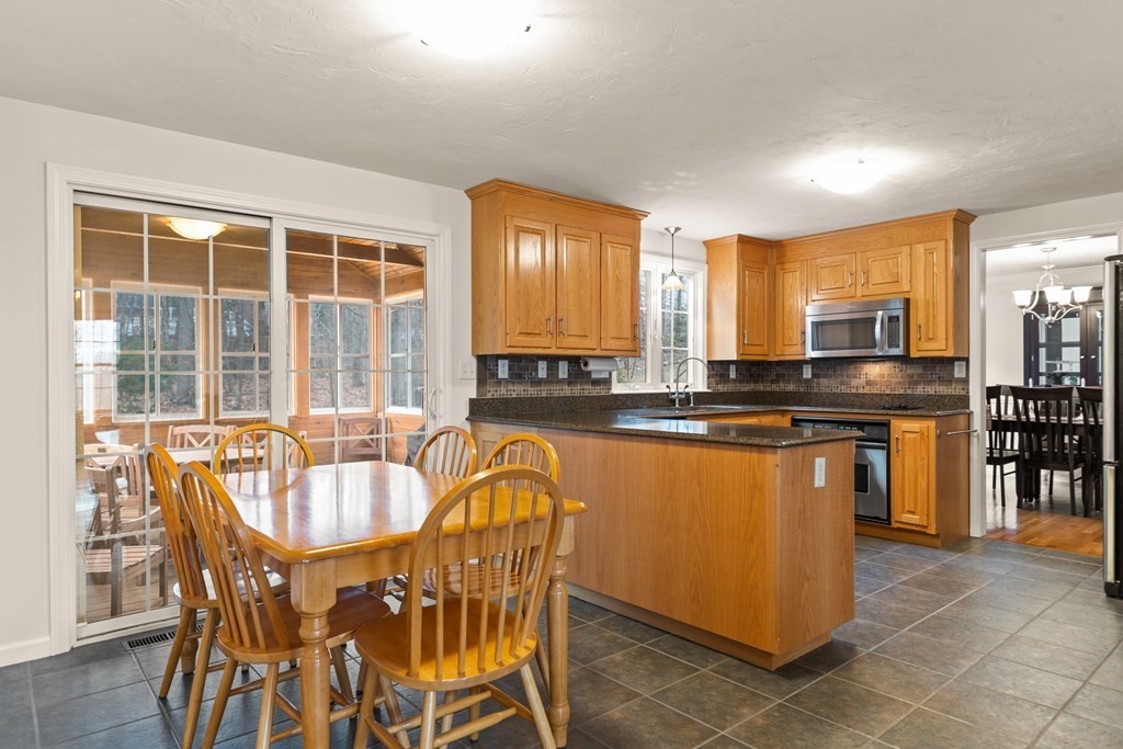 246 Morgan Road Whitinsville, MA 01588 - Photo 9 of 28 a kitchen with stainless steel appliances granite countertop a stove a sink a dining table and chairs