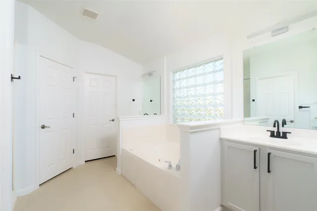 a bathroom with a sink a bathtub and a window