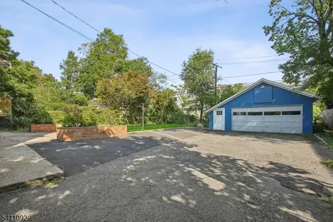 a view of a house with a yard and large trees