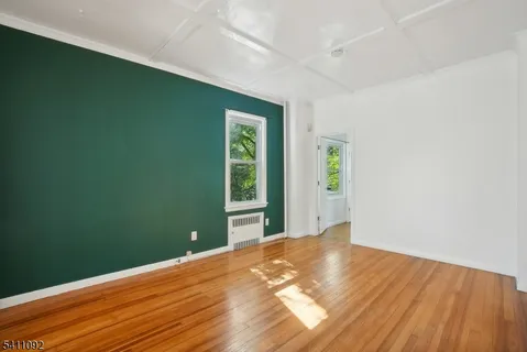 a view of a big room with wooden floor and windows