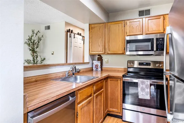 a kitchen with stainless steel appliances a stove sink microwave and cabinets