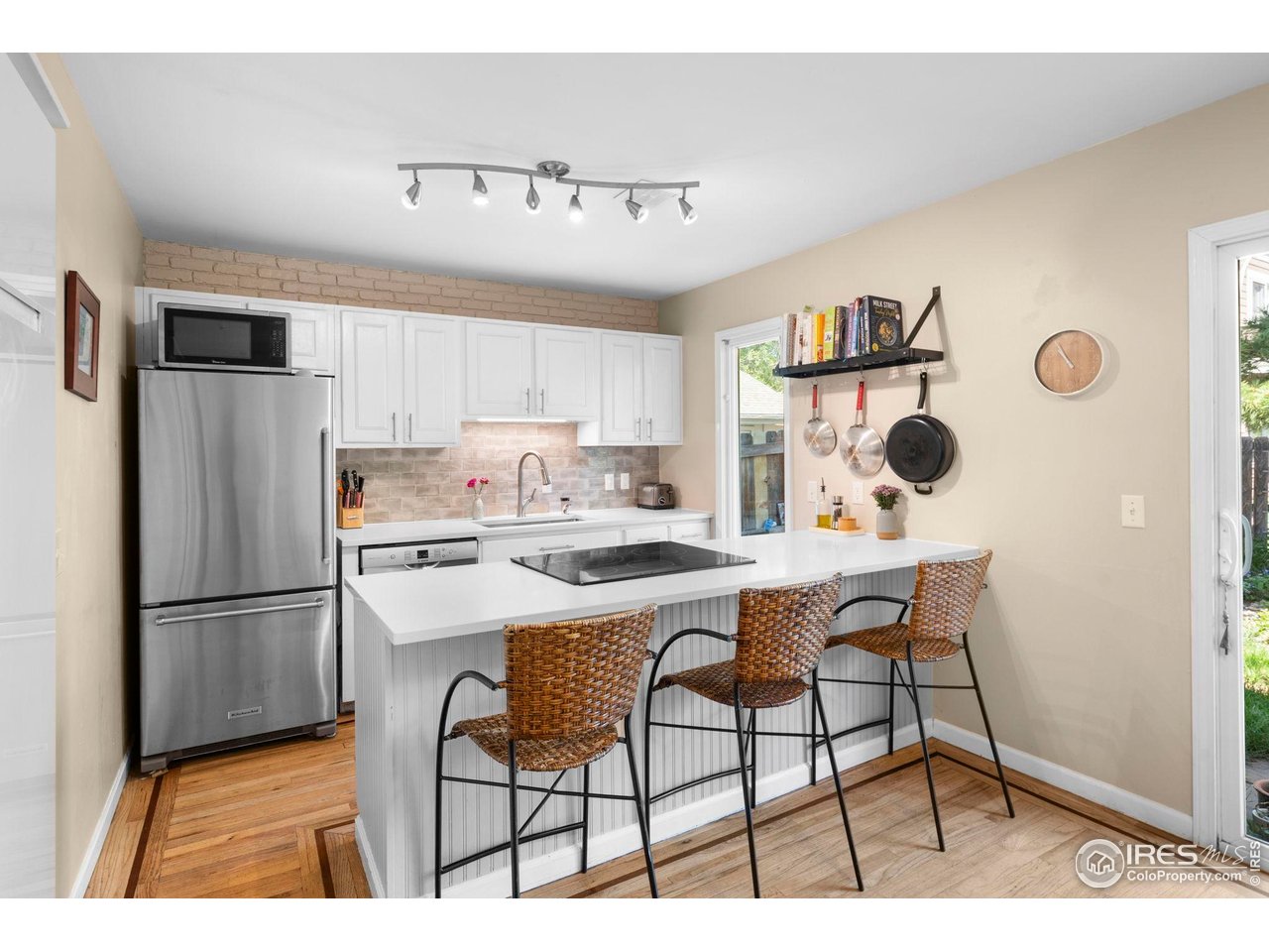 3878 Broadway, Unit 1 Boulder, CO 80304 - Photo 6 of 36 a kitchen with stainless steel appliances granite countertop a refrigerator a stove a sink and white cabinets with wooden floor