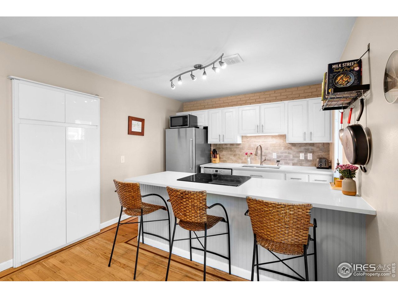 3878 Broadway, Unit 1 Boulder, CO 80304 - Photo 7 of 36 a kitchen with stainless steel appliances kitchen island granite countertop a dining table chairs and a refrigerator