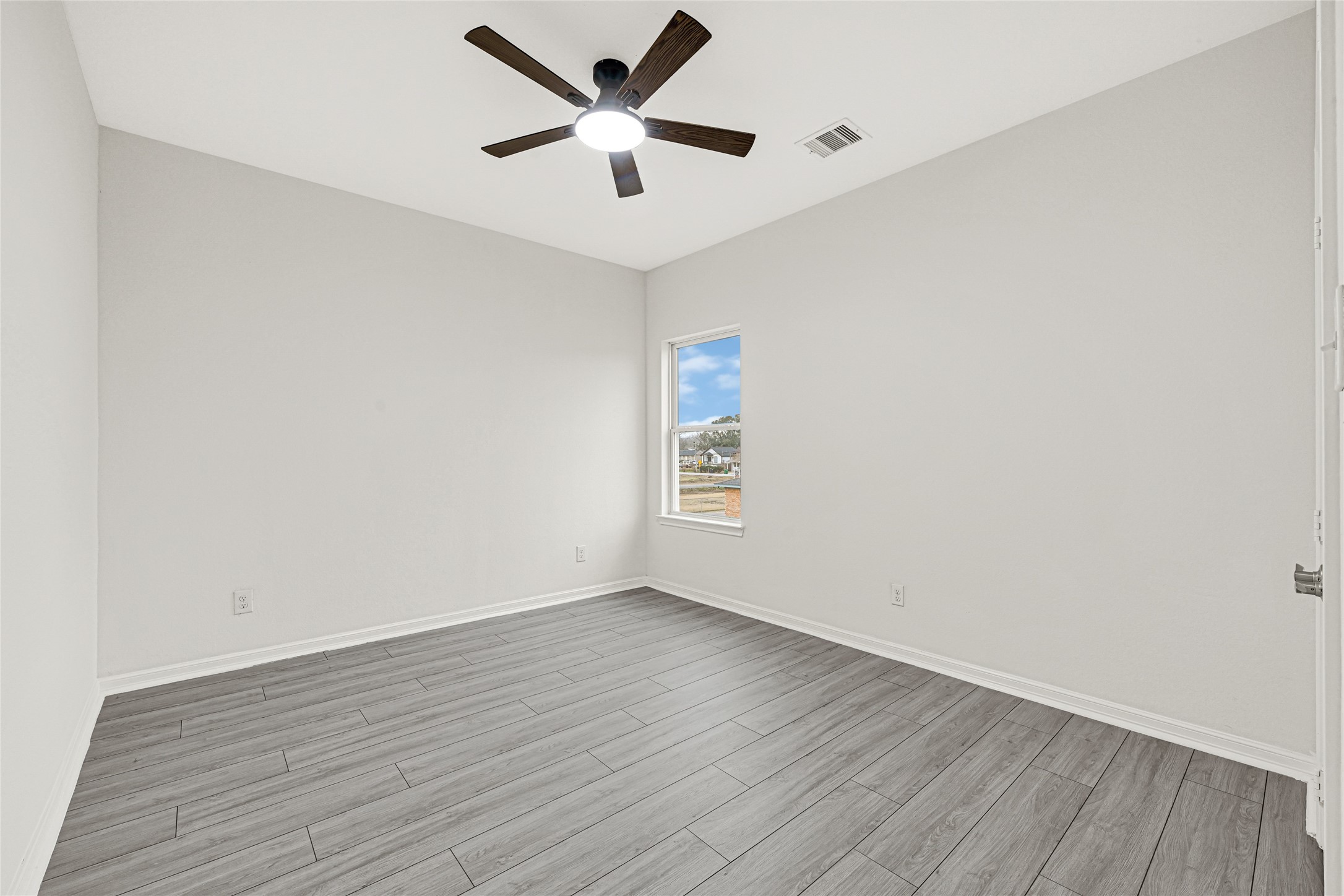 8628 Scott Street Houston, TX 77051 - Photo 17 of 22 an empty room with wooden floor and windows