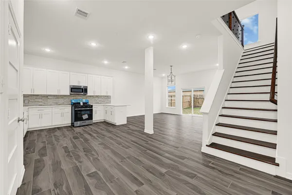 a view of kitchen with granite countertop stainless steel appliances and sink