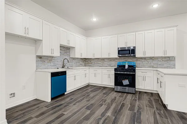 a kitchen with a refrigerator stove top oven and sink