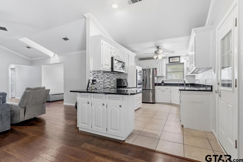 1302 Lake Cross Road Hideaway, TX 75771 - Photo 15 of 31 a large white kitchen with kitchen island white cabinets and stainless steel appliances