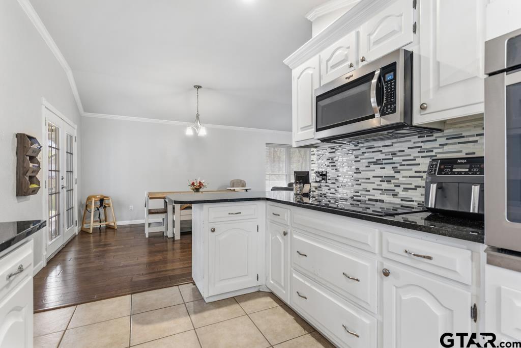 1302 Lake Cross Road Hideaway, TX 75771 - Photo 18 of 31 a kitchen with stainless steel appliances kitchen island granite countertop a stove a sink and a microwave
