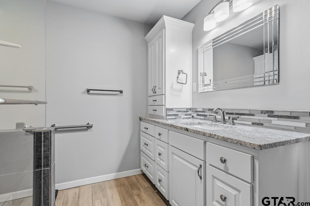 1302 Lake Cross Road Hideaway, TX 75771 - Photo 7 of 31 a bathroom with a granite countertop sink and a mirror