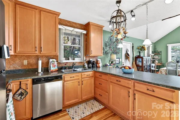 a kitchen with granite countertop a sink stainless steel appliances and cabinets